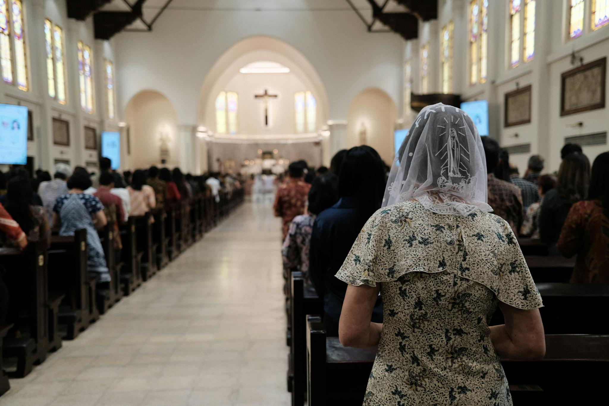 People gathered in an Indonesian church for a Mass service, showcasing community and faith.